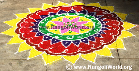 Freehand Rangoli with yellow leaves layer outline and pink flower in the middle